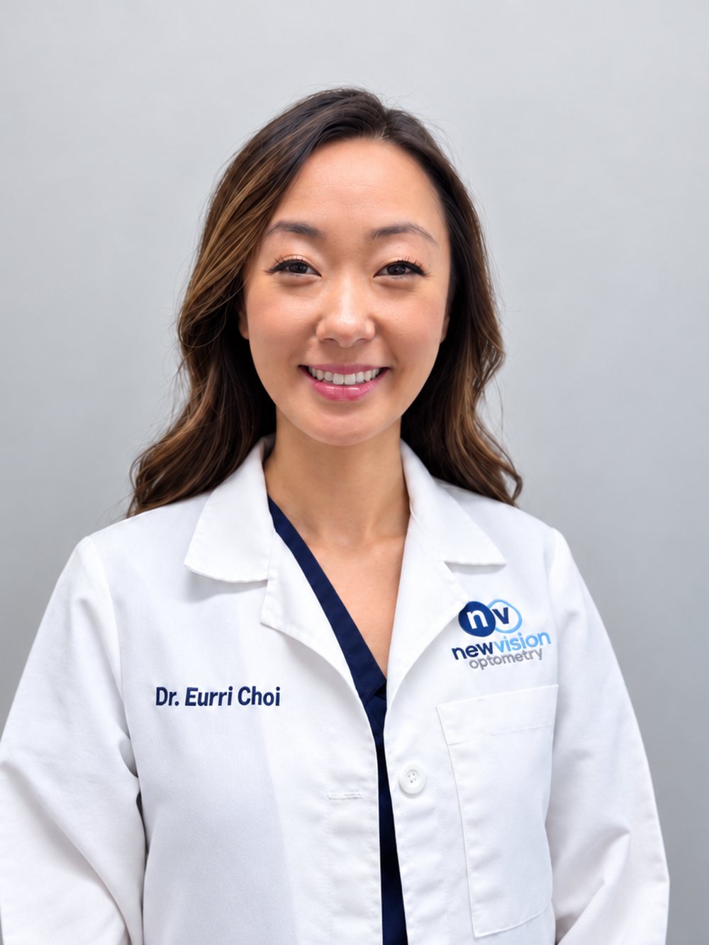 Portrait of Dr. Eurri Choi, O.D., in a white coat with the New Vision Optometry mark, photographed in September 2026