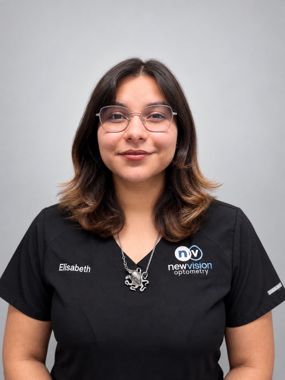Portrait of Elisabeth, Optician, in black New Vision Optometry scrubs