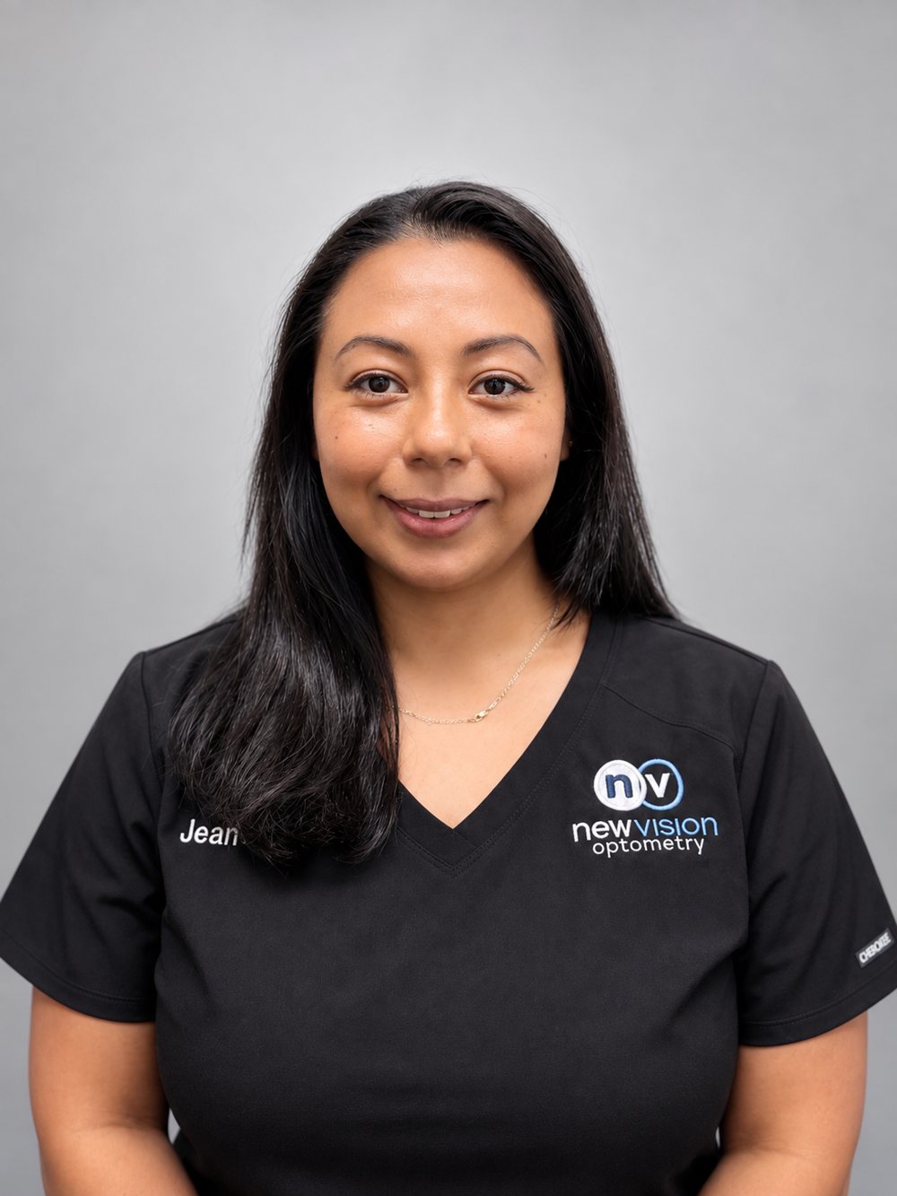 Portrait of Jeanette, Optician, in black New Vision Optometry scrubs