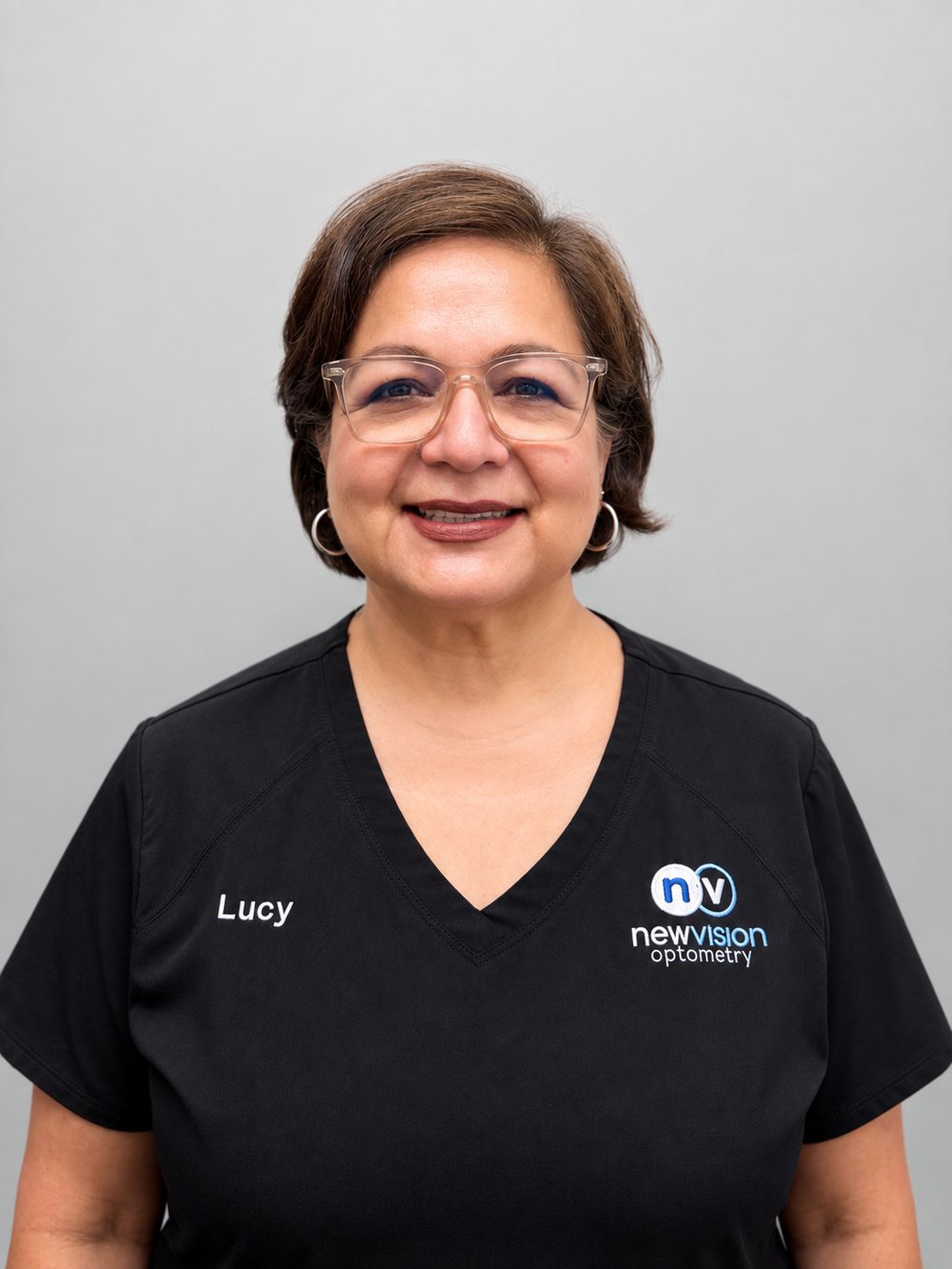 Portrait of Lucy, Lead Optician, in black New Vision Optometry scrubs