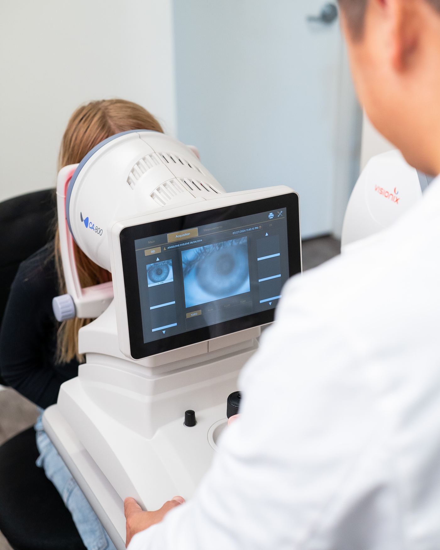 Over the shoulder of a doctor at the corneal imaging screen, a scan of the eye on the monitor, at New Vision Optometry