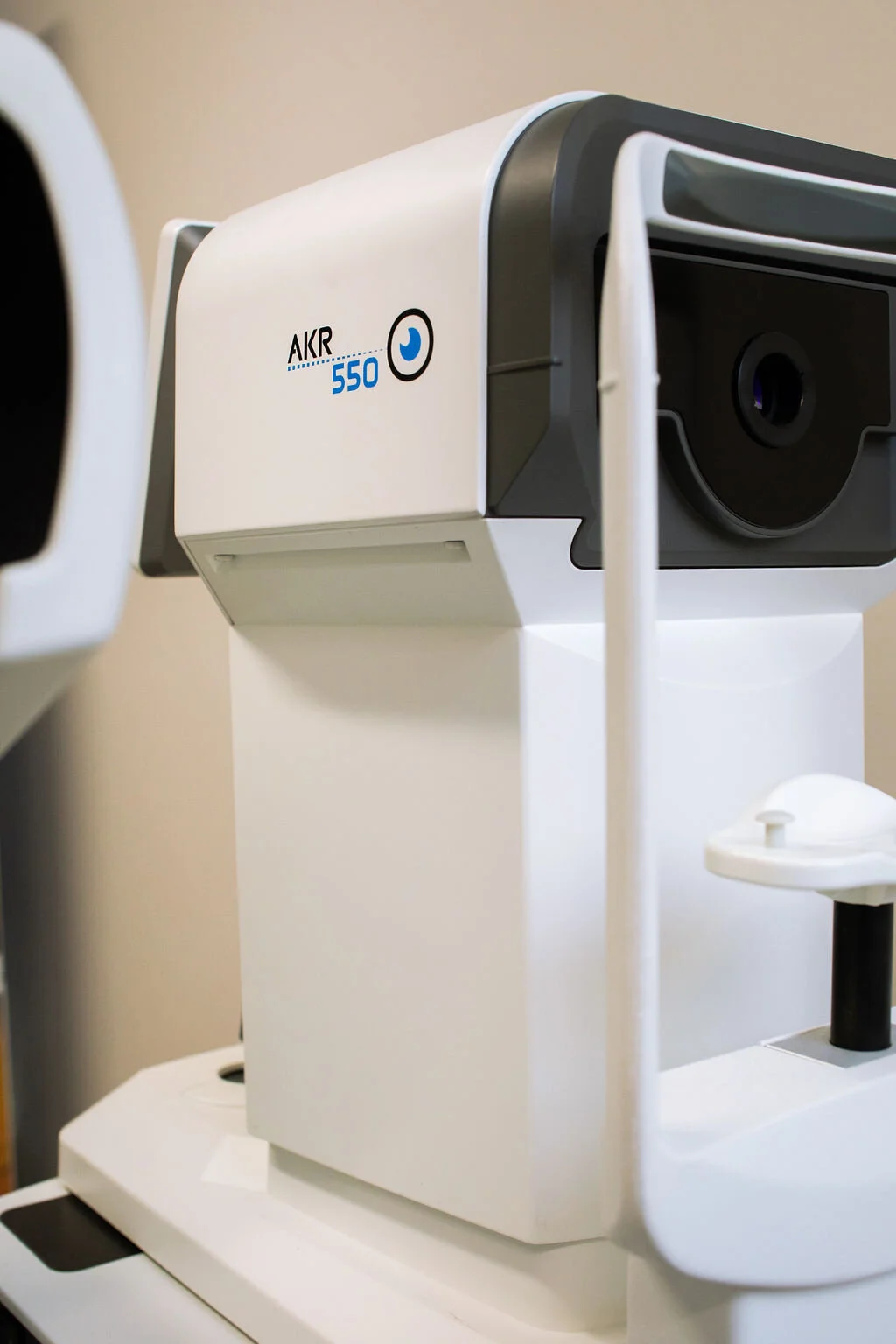 A diagnostic imaging instrument on a stand in the testing area at New Vision Optometry