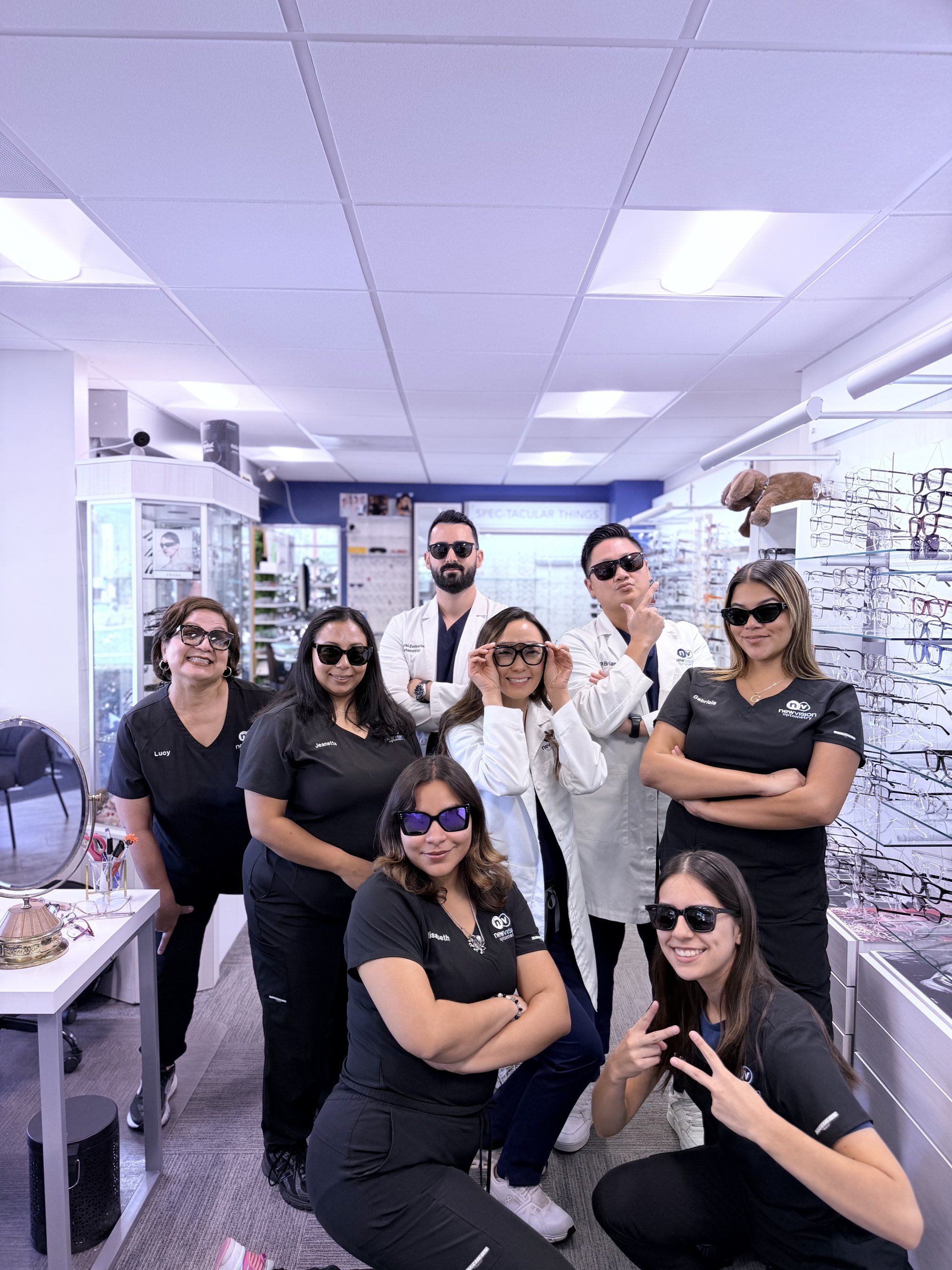 The New Vision Optometry team posed in the optical wearing sunglasses from the frame wall, the three doctors and five staff